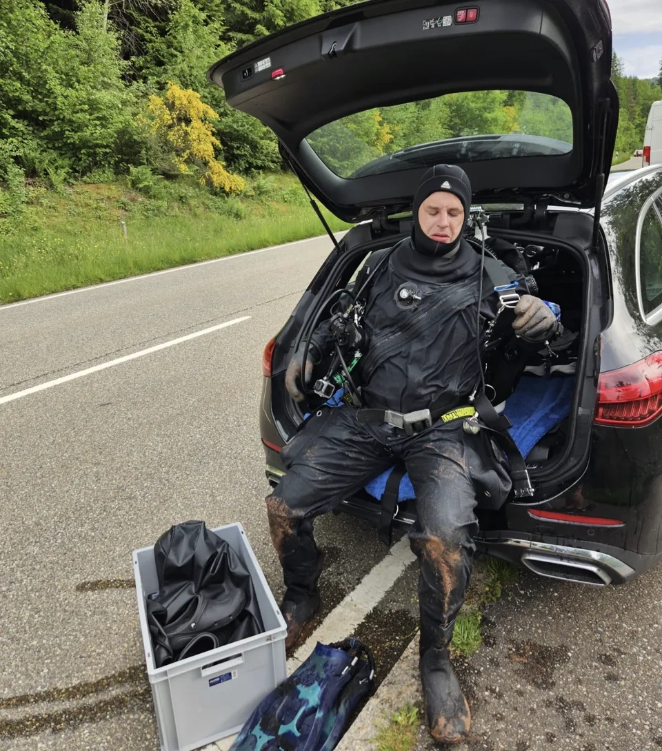 Taucher im Trockentauchanzug auf der Heckklappe nach einem Kaltwassertauchgang