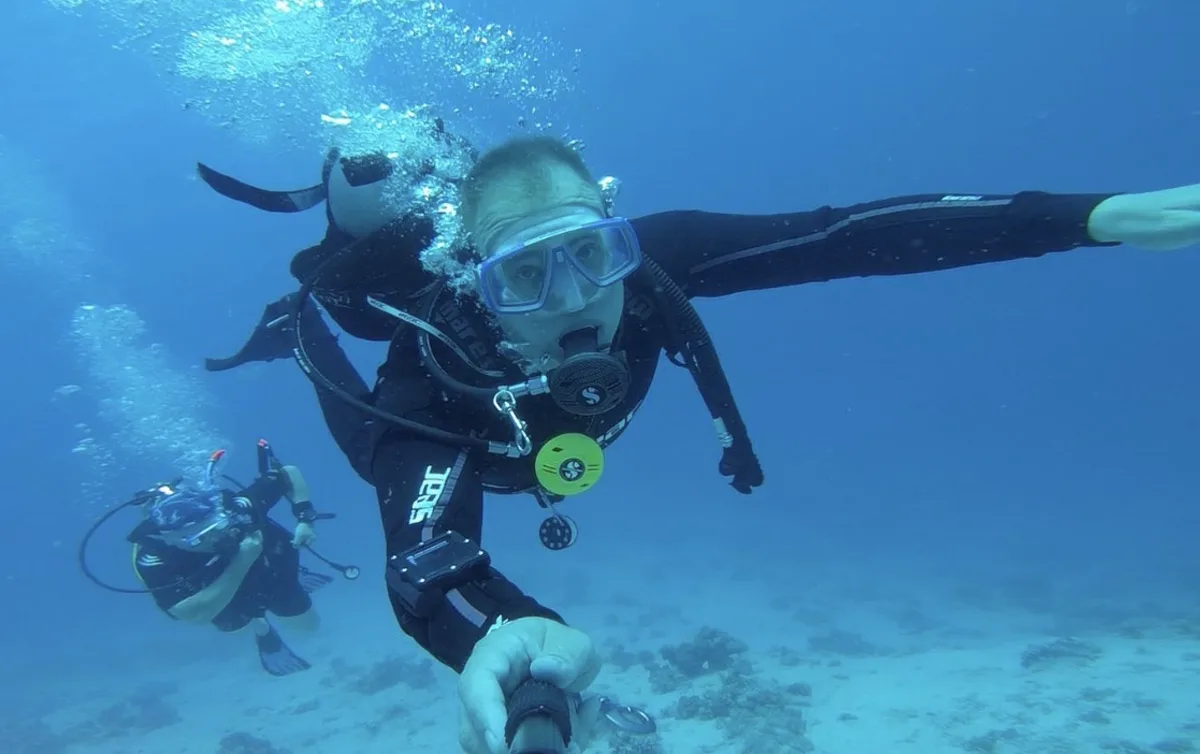 Taucher im Freiwasser mit Buddy im Hintergrund